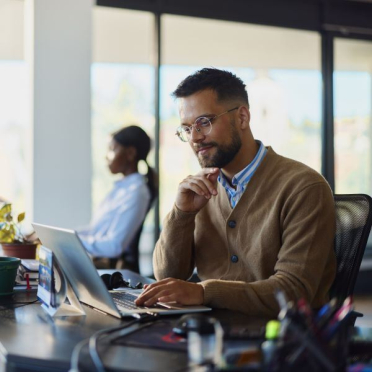 Man smiling while working on computer